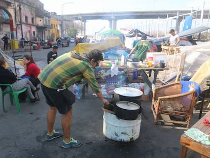 Homem cozinha em frente ao cortiço incendiado.