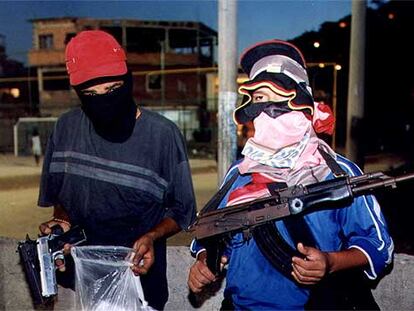 Dos niños enmascarados sostienen drogas y armas (pistolas y un fusil) en Río de Janeiro (Brasil).