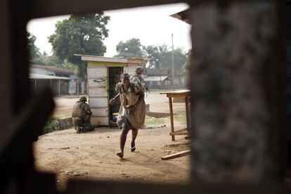 Una mujer corre a esconderse durante un intenso tiroteo en el distrito Miskin de Bangui, República Centroafricana.