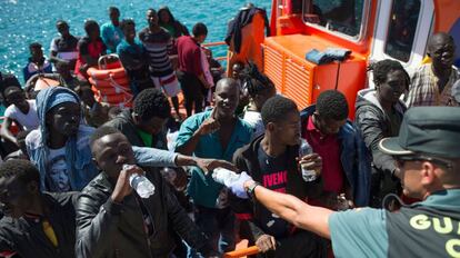 Un guardia civil reparte botellas de agua a los migrantes rescatados en Tarifa.