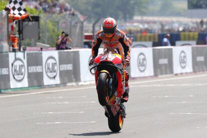 Marc Márquez realiza un caballito después de pasar primero por la línea de meta.