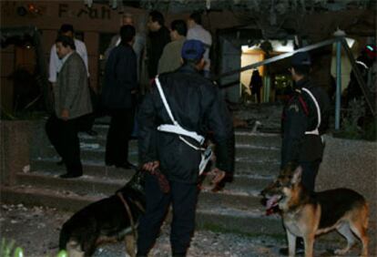Dos policías inspeccionan los destrozos causados por una bomba en la entrada del Hotel Safir.