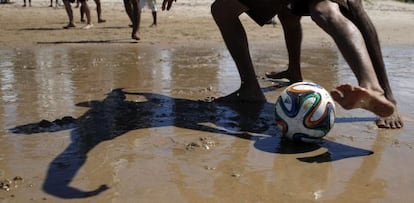 Un grupo de jóvenes juega al fútbol en la playa en Recife (Brasil).