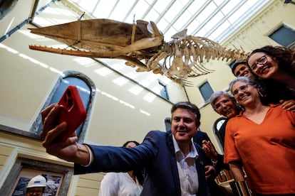 El ministro de Educación de Brasil, Camilo Santana, hace un autorretrato bajo el esqueleto de un cachalote, este lunes, en la exposición del Museo Nacional, en Río.