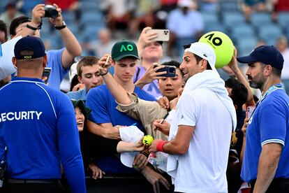 Djokovic firma una pelota a un aficionado.