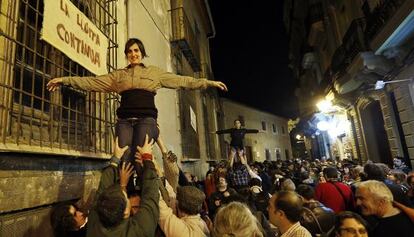 Los actores del &#039;mot&iacute; de Velluters&#039; cuelgan pancartas en las ventanas del Colegio Mayor de la Seda. 