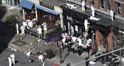 Investigators comb through the scene of one of the blast sites of the Boston Marathon explosions, Wednesday, April 17, 2013, in Boston. 