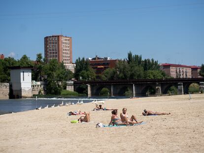 Varias personas disfrutan del sol y de la arena en la playa fluvial de las Moreras de Valladolid, el pasado 24 de mayo.