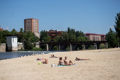 Varias personas disfrutan del sol y de la arena en la playa fluvial de las Moreras de Valladolid, el pasado 24 de mayo.