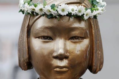 Una estatua en homenaje a las "mujeres de relax" luce una corona de flores puesta por una persona anónima durante la protesta semanal que cada miércoles se realiza frente a la embajada de Japón en Seúl, la capital de Corea del Sur, para reclamar una disculpa y una indemnización a las víctimas por parte del Gobierno nipón.