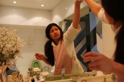 Las empleadas filipinas tienen más formación y son más caras. Una de ellas limpia un espejo en la casa libanesa donde trabaja.