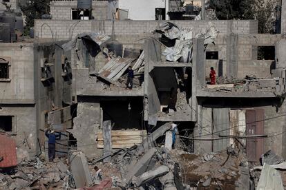 Palestinos entre las ruinas de un edificio residencial bombardeado por Israel, este lunes en Rafah. 