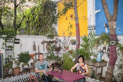 Nuria Yerro, junto a su pareja y su gato en el patio interior de su casa.