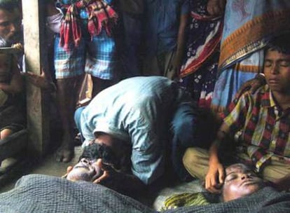 Familiares de dos víctimas del huracán lloran ante los cadáveres en la aldea de Goyara, a 300 kilómetros al sur de Dacca.