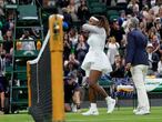 A referee helps Serena Williams of the US off the court after retiring from the women's singles first round match against Aliaksandra Sasnovich of Belarus on day two of the Wimbledon Tennis Championships in London, Tuesday June 29, 2021. (AP Photo/Kirsty Wigglesworth)