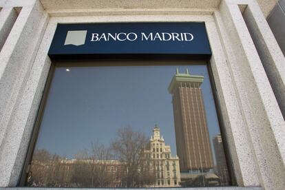 Los edificios de la Plaza de Colón se reflejan en una ventana del Banco Madrid.