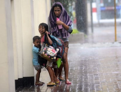 Una mujer, junto a sus hijos, abandonan la ciudad de Cebu, en el centro de Filipinas, ante la llegada del tifón Haiyan, 8 de noviembre de 2013.