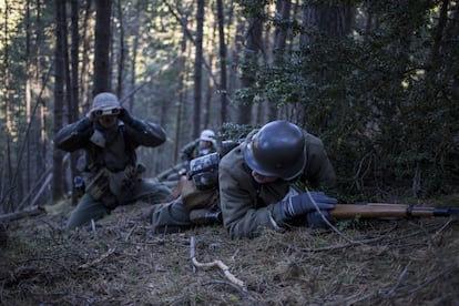 Un supuesto soldado alemán observa con los prismáticos mientras otros se protegen como si estuvieran frante al enemigo, en La Molina.