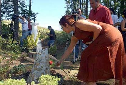 Maixabel Lasa coloca una rosa roja ante el monolito de Jauregi en el Monte Pagasarri.