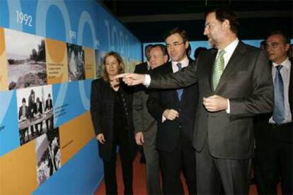 Mariano Rajoy señala una de las fotografías de la exposición sobre la historia del PP.