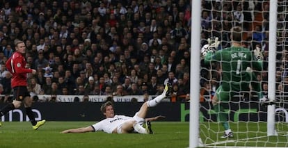 Manchester United's goalkeeper David De Gea (r) saves a shot by Real Madrid's Fabio Coentrão.
