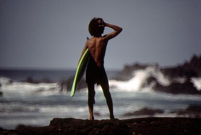 Un surfista, cerca de Milolii, en Hawái, donde en 1926 un río de lava alcanzó el océano durante una erupción del Mauna Loa.