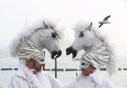 Dos personas vestidas de caballo en la plaza de San Marcos en Venecia (Italia).