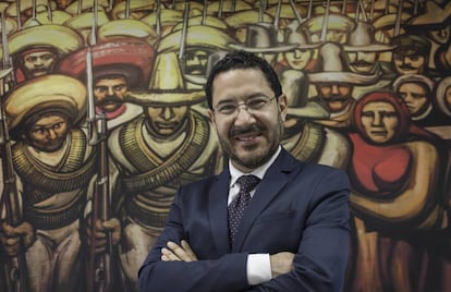 Mart&iacute; Batres frente a una reproducci&oacute;n de un mural de Siqueiros. 