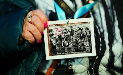 Miriam Ziegler, superviviente canadiense del Holocausto, sostiene una foto suya (rodeada con un círculo) mientras asiste a la ceremonia de conmemoración del 80 aniversario de la liberación de Auschwitz, en Oswiecim, Polonia, 