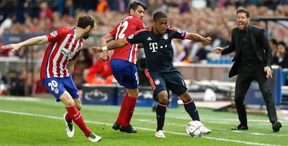 Douglas se lleva el balón ante Juanfran y Augusto en presencia de Simeone.