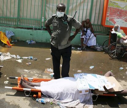 Un miembro de seguridad junto a un peregrino musulmán tras un aplastamiento causado por un gran número de personas en el Mina, fuera de la ciudad musulmana Santa de la Meca.