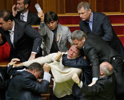Un diputado ucranio, apunto de golear a otro con una botella de agua, en medio de la trifulca parlamentaria.