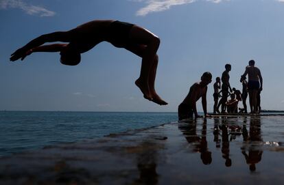Un niño salta al Mar Negro desde un muelle en el centro de Sochi, Rusia.