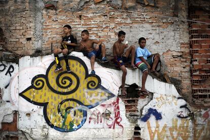 Crianças olham uma partida de um torneio organizado por movimentos sociais que protestavam contra a despesa pública para a Copa do Mundo do Brasil 2014, em São Paulo.