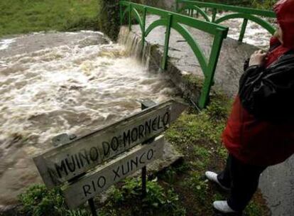 Una vecina de la localidad lucense de Cervo mira la crecida del río Xunco