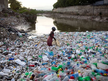 Una mujer entre botellas de plástico en un canal de la barriada de Cite Soleil, en Puerto Príncipe, Haití.