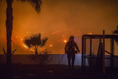 Un bombero intenta proteger una casa en Lilac, cerca de Santa Ana (California).