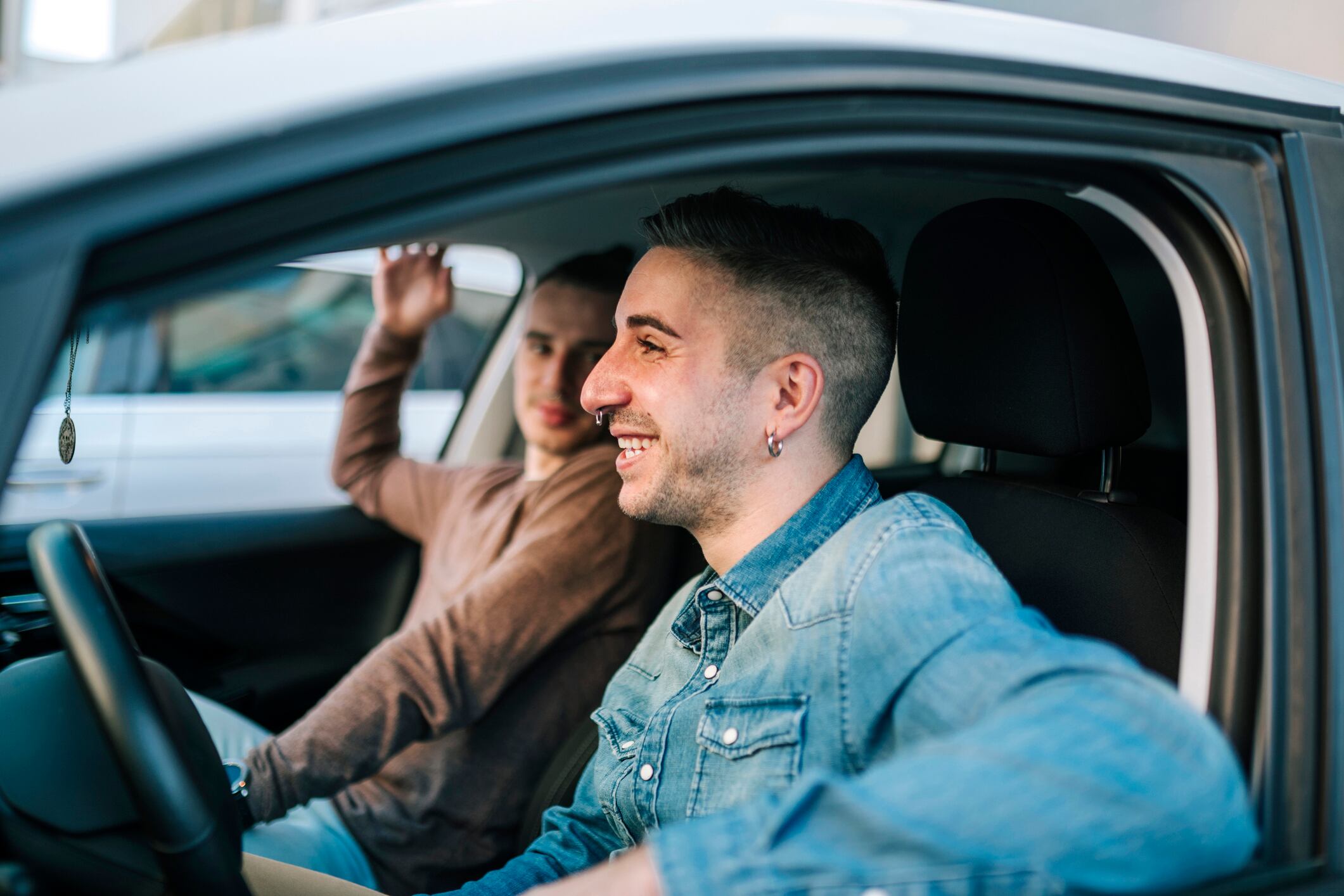 Un joven lleva a su amigo en coche.