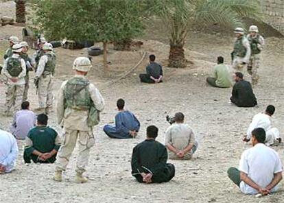 Soldados estadounidenses vigilan a un grupo de iraquíes detenidos en las cercanías de Tikrit, en Irak.