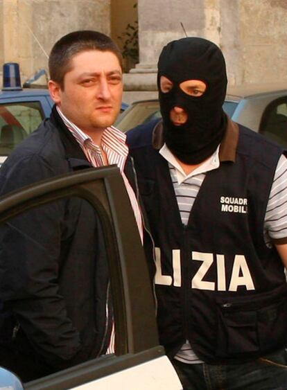 Un policía escolta a Nicola Schiavone, el heredero del clan camorrista de Los Casaleses, tras su detención el 15 de junio de 2010.