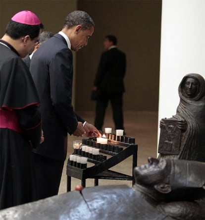 Barack Obama enciende una vela como homenaje a monseñor Romero en su cripta en la catedral de El Salvador.