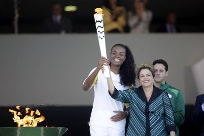 La jugadora de voleibol brasileña que ganó el oro en los Juegos Olímpicos de Pekín 2008 y Londres 2012, Fabiana Claudino (i), y la presidenta de Brasil, Dilma Rousseff (d) sostienen la llama olímpica.