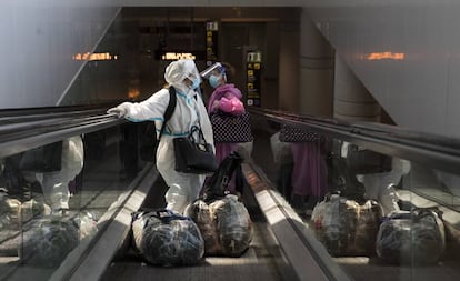 Two women arrive at El Prat airport in Barcelona on Sunday.