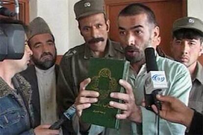 Abdul Rahman, el afgano convertido al cristianismo, sostiene una Biblia ante las cámaras de televisión.