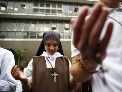 Religiosa reza em frente à Câmara durante votação do plano.