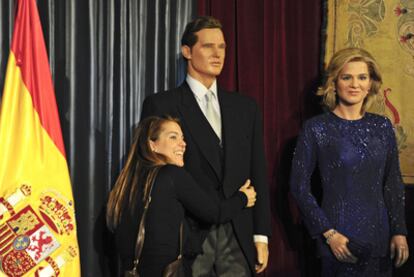 Una mujer posa con las figuras de Iñaki Urdangarin y la infanta Cristina en el Museo de Cera de Madrid.