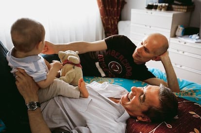 Pedro Fuentes (con su hijo Alonso encima) y su marido Javier González, hace cuatro años.