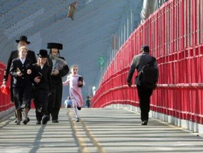 Familias jud&iacute;as cruzan el puente de Williamsburg.