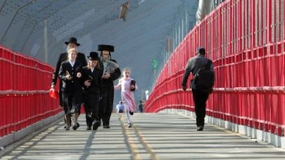 Familias judías cruzan el puente de Williamsburg.