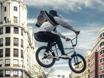 Un hombre tranquilo vuela sobre una bicicleta por las calles de Madrid.